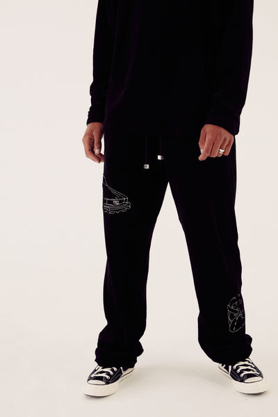 close up of car embroidered black velour tracksuit bottoms