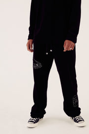 male model in black velour tracksuit bottoms
