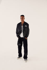 male model wearing satin bomber jacket and velour tracksuit bottoms