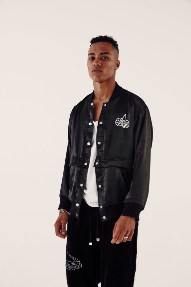 male model wearing satin bomber jacket and velour tracksuit bottoms