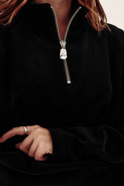 close up of female model in black velour zip fleece showing zip detail